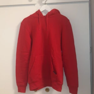 Röd hoodie - Röd simpel tröja med snören och uni pocket.