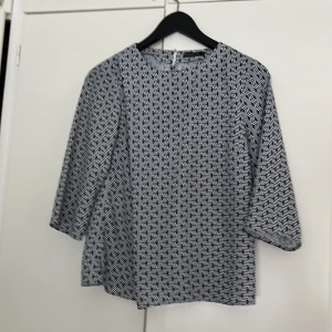 Blus - Vit med marinblått mönster. 