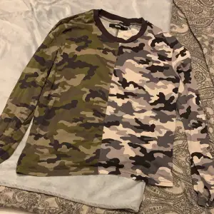 En kamouflage färgad tröja från Bik Bok, med svartvit och grön färg. Väl använd men är i bra skick! 👍👍 Storlek XS men är ganska stor i storlek så den passar en M. !OBS! Köparen står för frakten! (Intryckta frakten stämmer ej) 👇👇👇