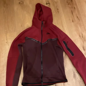 Nike techflecce röd xs - Nike tech flecce röd/ mörkröd i bra skick. Använd bara ett antal ggr och ingen skada på den. Anledningen till att jag säljer, byte still