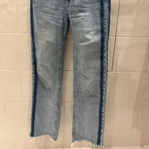 Kick Flare Jeans  - Jeans från Black Orchid (köpta på NK). Kick flare, avklippt detalj nedtill, mörkblå streck längs sidorna (det är samma modell som andra bilden fast mörkblå streck istället, se bild 1 och 3). Knappt använda. Köpta för ca 2 000 kr, säljer nu för 399.