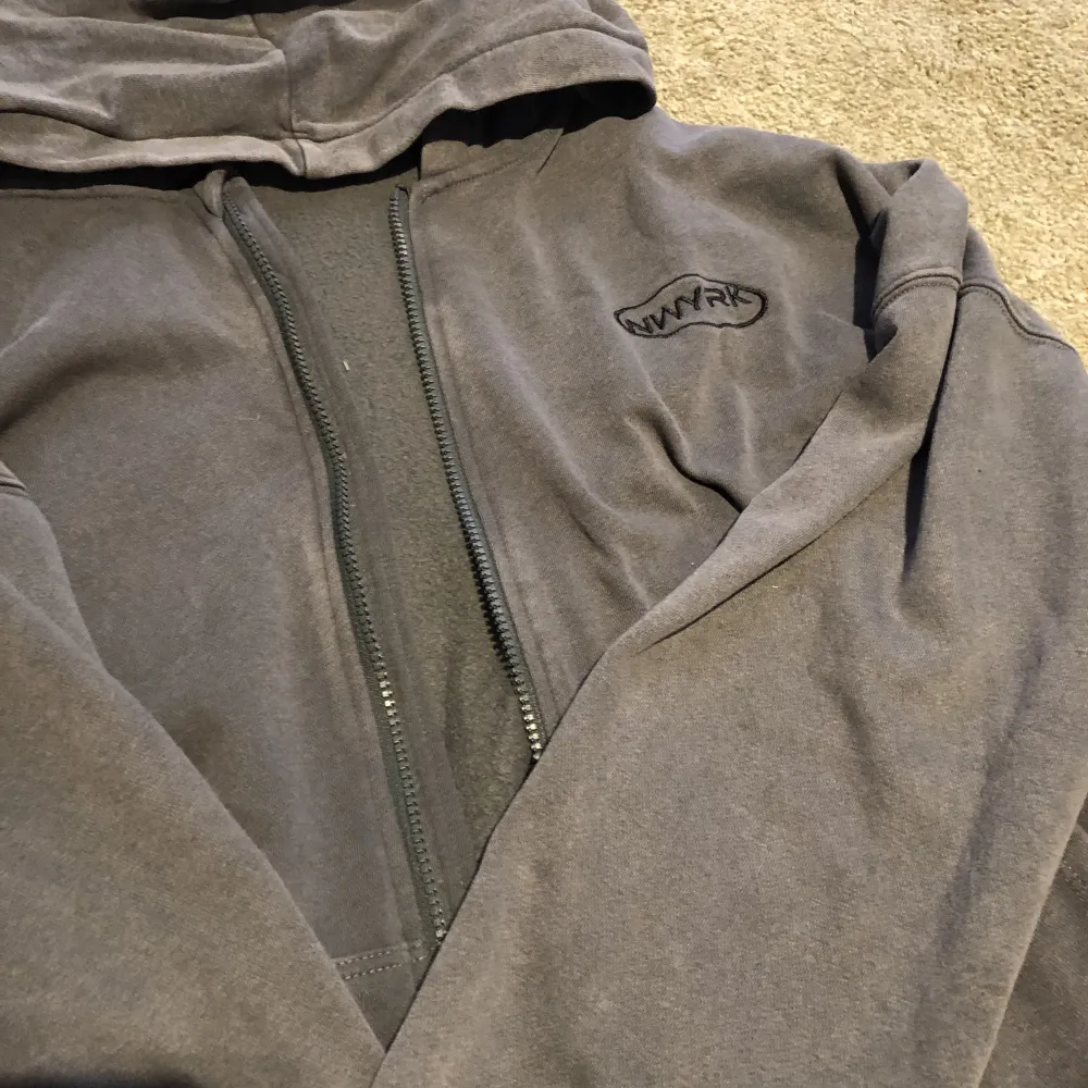 En grå zip up hoodie i storlek 170! Tröjan har ett nwyrk tryck på bröstet!! Säljer tröjan då jag har tröttnat på den, i gott skick🤍🤍. Hoodies.