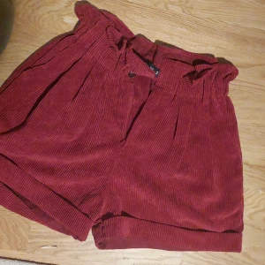 Mörkröda shorts - Väldigt fint skick i storlek S men är töjbara. Finns möjlighet att ha skarp till. Fin mjuk tyg och har endast anvönts ett fåtal gånger. Jättefint med höga strumpor om man gillar den stilen