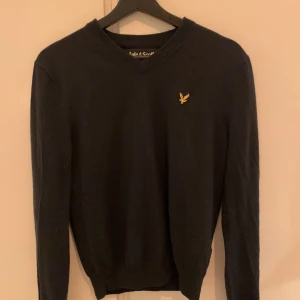 Merinoull tröja Lyle & Scott  - Mörkt blå tröja från Lyle & Scott som krympt i tvätten. Från början storlek small herr men sitter nu mer som en dam small. 