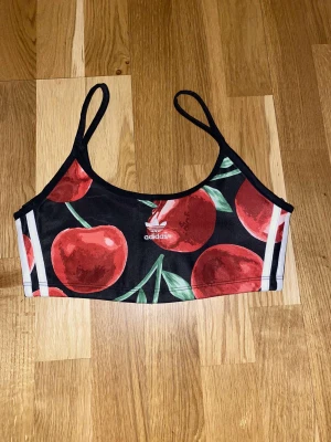 Adidas med körsbär 38 - Adidas tränings top med körsbär på!   Svart och vita toppen är från hm tillsammans, båda för 100 kr och storlek small 