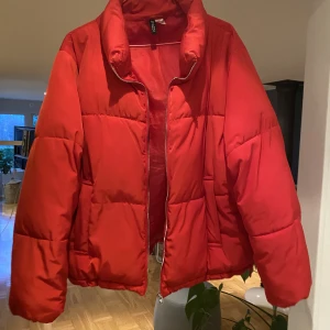 Röd pufferjacket - Säljer denna röda pufferjacka från HM. Köpt några år sedan och använt lite. Den är i väldigt bra skick och väldigt varm! Säljer för jag inte använder den längre. Storlek 44. 150kr + frakt. Pris går dock att diskuteras ☺️