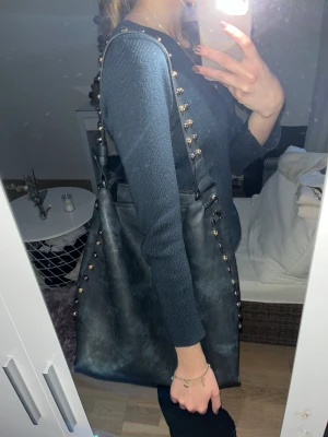 Marinblå väska - En super fin marinblå väska i väldigt bra skick! Den har guldiga och mörka detaljer på banden och sidan om🫶🏼💞 Man kan använda den som skolväska, den får plats med dator och böcker💞