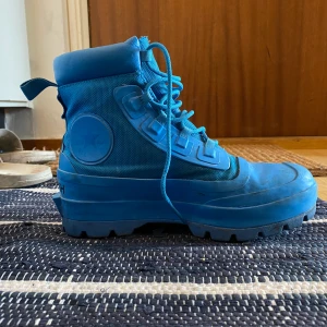 CONVERSE x AMBUSH SHOES - Blå Converse x AMBUSH Chuck Taylor All-star duck unisex boots. Bara använda några få gånger, säljer på grund av fel storlek!   I jättebra skick, lite smuts som går lätt att tvätta bort men hela och som sagt knappt använda. Mkt mkt fina 🥹🥹  Storlek: EU39.5