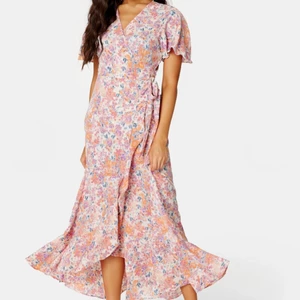 Klänning (använd en gång) - OBS! Behöver veta senast fre 17/6 om du ska ha till midsommar   Endast använd en gång, köpte sen samma i kortare version 😅 Härlig omlottklänning. Perfekt till midsommar och varma sommardagar.  Nypris 559kr