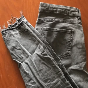 H&M gråa jeans stl 42 - Använda några gånger! <3 Har två mörkare ”lappar” på byxbenen och lite slitning i slutet av benen!