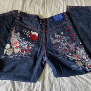 Fetta jeans med tryck  - Evisu/ed Hardy liknande jeans. Får inte någon användning av dem. Bra skick. Baggy. Storlek w36/l32. Säljer fler jeans med tryck. Midja: 88cm. Innerben: 82. Ytterben: 112. Lår rakt över: 34. Säljer direkt! 