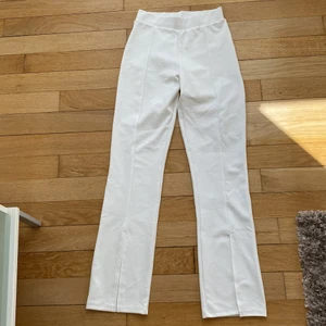 Vita leggings med slits  - Vita leggings med slits nere vid anklarna. Väldigt fina men har tyvärr växt ur den. Haft dem i ca 2 år men har bara fått användning av dem ett fåtal gånger. Finns i storlek XS men passar även S. 100kr exklusive frakt