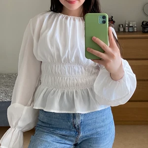 Vit tröja från NA-KD i storlek 36 - Väldigt söt vit tröja med puffiga ärmar. Har använt den EN gång (på studenten). Tröjan är som ny. 