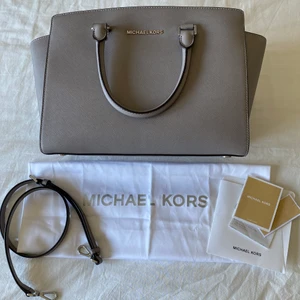 Michael Kors - Säljer min Michel Kors väska i modellen Selma färgen PEARL GREY. Västan är endast använd vid ett fåtal tillfällen och därav i fint skick. Väskan är köpt i Michael Kors egna butik i Köpenhamn, nypris 2800kr. Vid frågor eller om du vill ha fler bilder är du välkommen att höra av dig💘