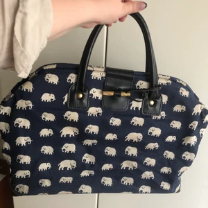 Svenskt tenn Elefan stor väska - Förstärkt och lätt impregnerat lin i fin mörkblå färg. Detaljer i svart skinn och mässing. Varsamt använd, god kvalitet. Denna färgkombination säljs inte längre i butik, nypris 2400kr. Upphämtning sker på Gärdet i Stockholm. Tillhörande nyckelring saknas.