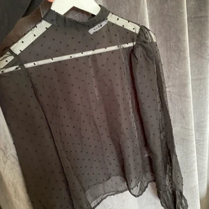 Blus med detaljer  - En svart blus från nakd som är halvt genomskinlig med svarta prickar på. 
