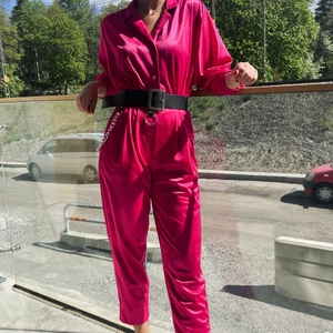 Rosa byxdress, storlek S  - En jättefin vintage byxdress jag fått av min mormor, osäker vart den är köpt med den är knappt använd av varken mig eller min mormor! Sitter fint på mig och jag är ca 164 cm lång så den kan eventuellt vara lite kort i benen om man är längre! Skärpet ingår inte