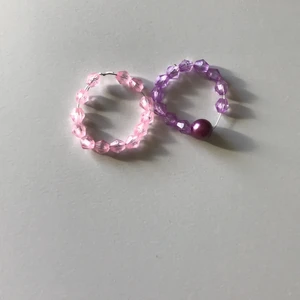 2 ringar i färgerna rosa och lila!  - Säljer dom här 2 ringarna jätte fina om man ska klä upp sig eller bara ansvända i vardag. Har aldrig använt dom förut klämmer inte ått på fingrarna det bror på vilken storlek man har men super fina ringar hoppas någon får användning för dom!💗💗