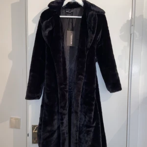 Kappa Päls - En fluffig kappa i fakepäls.  Har prislapp kvar då jag aldrig använt den, endast testat! Den är i petite storlek & jag är 160cm.  Nypris är 700kr