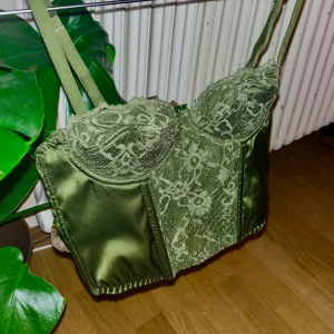 Grön Korsett - Träskgrön Korsett. Aldrig använd då kuporna är små för mina bröst :/