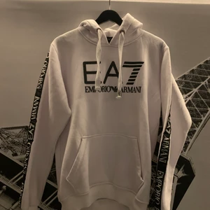 Vit EA7 Emporia Armani hoodie - Säljer denna fina hoodien för att den inte passar mig längre.En riktigt bra hoodie som är i bra skick 9,5/10.Har inte några skador eller något på hoodien därför är den i bra skick.Ett bra tips för er som gillar hoodies väldigt bra till sommarkvällar.Riktigt skön att använda.Nypris 1099kr.Storleken är L men passar ganska bra till dom som använder M med.Pris kan sänkas vid kontakt