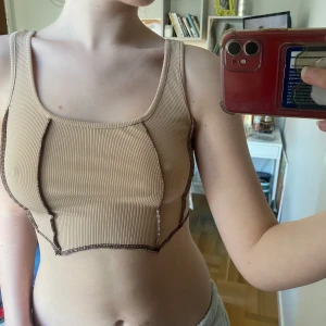 Sommar topp  - Beige sommar topp med svarta sömmdetaljer. Använd någon enstaka gång och är i bra skick. Storlek XS-S men är väldigt stretchig så passar nog M också🥰