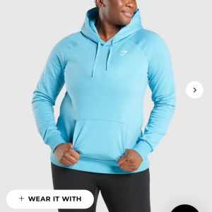 Gymshark hoodie - Säljer min blåa hoodie från gymshark , med otroligt fin blå färg. 💙 Färgen är inte riktigt lika ljus som på hemsidan men min bild är inte heller helt rättvis.  Den är strl XS men passar lika bra S. Tröjan har en liten liten fläck som ett blyetchstreck typ (sista bilden) , syns verkligen nt när man har på men vill ändå visa att den finns. Köparen står för frakt. 