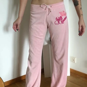 Rosa Juicy Couture Mjukisbyxor - Rosa Juicy Couture Mjukisbyxor, i storlek L men passar mer som en S. i nyskick🛍💖🎀🌸🧸 Min kompis på bilden är 166 och de sitter bra på henne, lite för långa på mig som är 160 🫶🏻