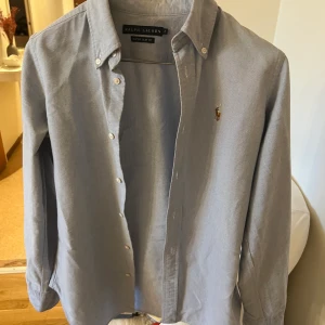 Ralph Lauren Skjorta - Ljusblå skjorta från Ralph lauren. Säljes då den blivit för liten för mig. Slim fit modell. Xs-s
