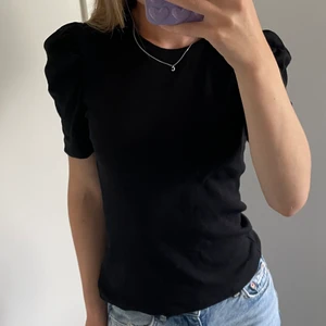 Svart topp med puffarm  - Svart topp som är grov i materialet. Storlek xs. Från VILA. En väldigt fin puffarm/lite volang vid axlarna. Sälj på grund av att jag är en likadan💓