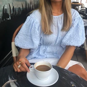 Blå/grå topp  - Supersöt topp med puffärmar och knytning i bak. Så gott som oanvänd då jag köpt i fel storlek! Är i en ljusblå/grå färg 