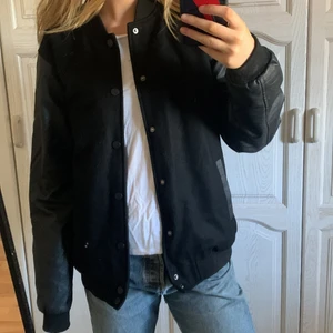 Baseballjacka - Svart baseballjacka med armar i läderimitation. Oversize på mig som oftast är S. Frakt 59 kronor. (Vid snabb affär säljer jag för 200+frakt)