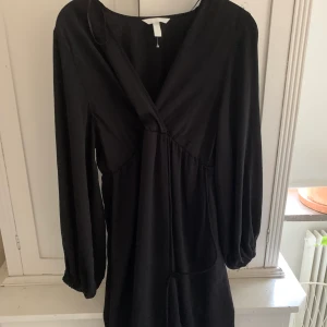 Svart Wrap dress  - Svart wrap dress, står att den är från ”mamma avdelningen” men jag skulle inte säga att det märks på något sätt, tror bara de menar att det är lätt att amma. Aldrig använd, strl M/L, frakt tillkommer!