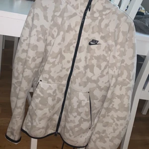 Vit/Svart Nike tech fleece Passar S/M - Hej, Säljer tröjan på grund av för stor storlek! Har inte använts så mycket! Byxor kan tillkomma! Dock är storlek på byxorna XS