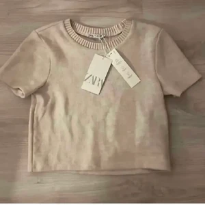 Zara tröja - Populär t-shirt från zara😍 oanvänd o har en vit/ beige färg, pris är diskuterbart vid snabb affär, skriv vid frågor🌸