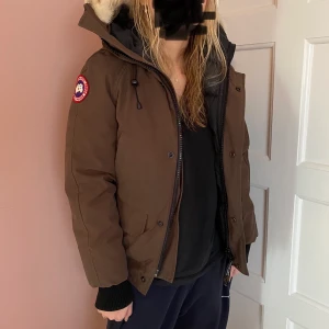 Chilliwack canada goose jacka brown  - Supersnygg jacka, säljer pga för liten. Jackan är köpt begagnad, och kvitto saknas. Jag tror att den är äkta efter att ha kontrollerat lappar och material mm, men kan inte garantera. Jackan är i bra, men använt skick. Har några små slitage, knappt synliga