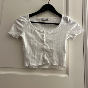 T-shirt -  en fin vit t-shirt med knappar på framsidan och små blommor.🤍