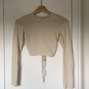 Tight tröja monki - En tight, långärmad, bege, tunn tröja med öppen rygg från monki (40kr köpt för 100) använd väldigt få gånger.