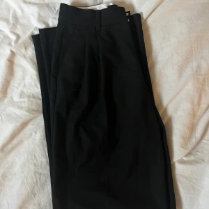Svarta kostymbyxor med pressväck - Säljet mina zara kostymbyxor i lite tjockare material. Lös fit med pressväck 