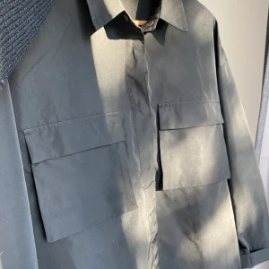 Polyesterskjorta Gina Tricot - Säljer denna skjortan som är i polyestertyg vilket gör att materialet känns likt en utomhusjacka, oversized passform. Använd en gång så den är i nyskick☀️