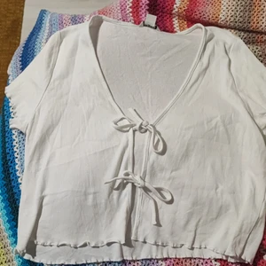 Vit ribbad tröja med snörning - Vit ribbad tröja med snörning fram. Storlek L och i väldigt fint skick.