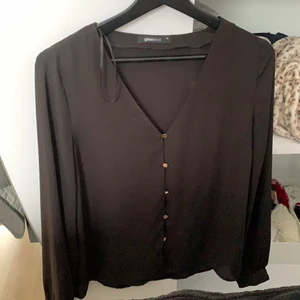 Skjorta/blus  - Svart skjorta/blus med guldiga knappar. Endast använd 1 gång. Köpt på Gina Tricot