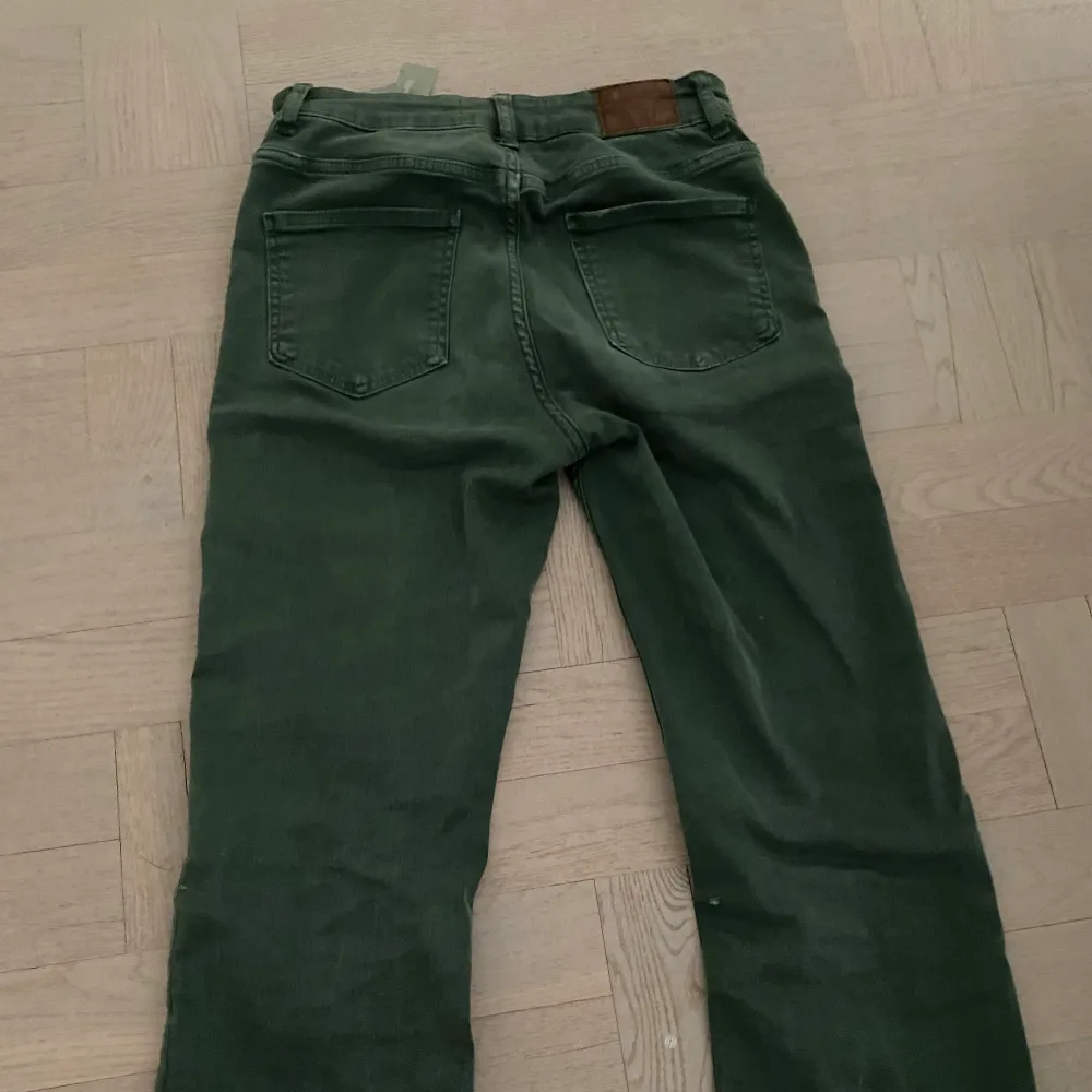 Ett par skitsnygga gröna jeans från Zara med hög midja och flera knappar! Jeansen är utsvänga nertill och sitter väldigt smickrande över benen. Storlek 38! Köparen står för frakten.. Jeans & Byxor.