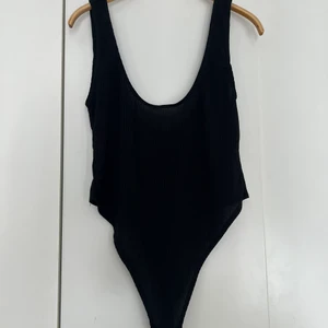 Ribbad body - Svart ribbad body med knäppning. 