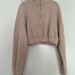 Cropped Sweatshirt med dragkedja - En sweatshirt i croppad modell. Halv dragkedja i kragen.