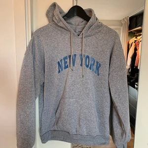 Hoodie - Grå hoodie från shein med new york skriver över den med blå bokstäver. Det är en storlek M men skulle snarare säga s. Väldigt mjuk på insidan