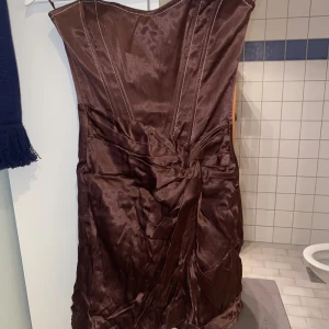 Sammetsklänning - Sammetsklänning utan band i brun färg. Perfekt till fest. Den är inte struken därför ser den skrynklig ut