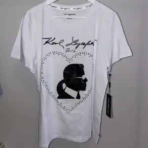 T-shirt med tryck och stenar, från Karl Lagerfeld. Helt ny, oanvänd med lappar kvar. Funkar till att vara uppklädd men också till vardags. 