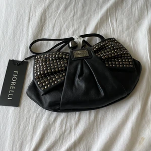 Väska  - Säljer helt ny och oanvänd FIORELLI vÄska som inte är öppnad eller andvänd skriv för fler säljer nu en helt ny och oanvänd FIORELLI helt helt ny väska skriv om bilder är köpt för 750kr och säljer nu för 450kr+frakt skriv vid funderingar och pruta på  ❤️