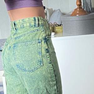 Oanvända Denim jeans med ”urtvättad” look från Berhska. 90s fit. Framhäver figur, faller löst.  Byxorna är blå/grön melerade.